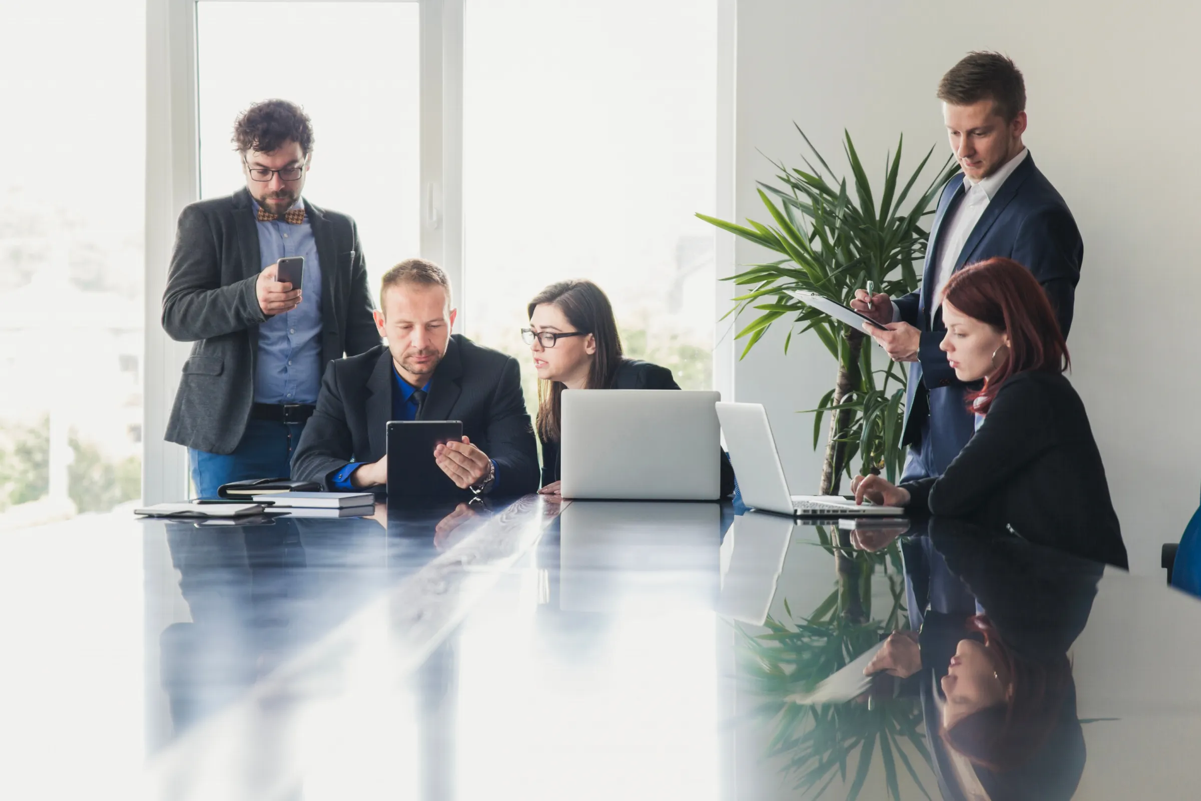 Business team meeting around a glass table with laptops
